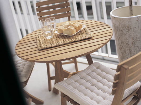 Wooden garden furniture give the balcony a rustic look. The Vendia table with chairs from Skagerak is the perfect place for a wonderful open-air breakfast.