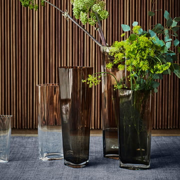 The large Collect vase from & Tradition in smoke with green grasses on a blue background