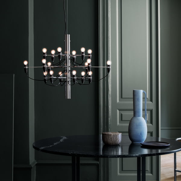 The chrome chandelier 2097/18 from Flos over a round black dining table